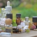 bottles of essential oil with plant and flower  on a wooden table in garden